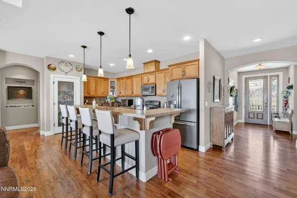 a kitchen with stainless steel appliances kitchen island granite countertop a refrigerator a stove a kitchen island with a dining table and chairs