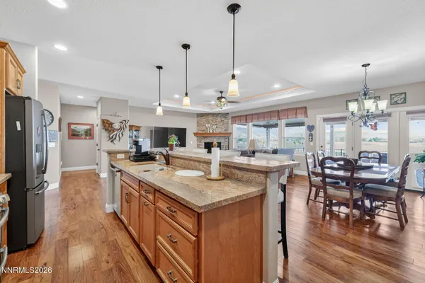 a kitchen with stainless steel appliances granite countertop a sink a stove and a wooden floor