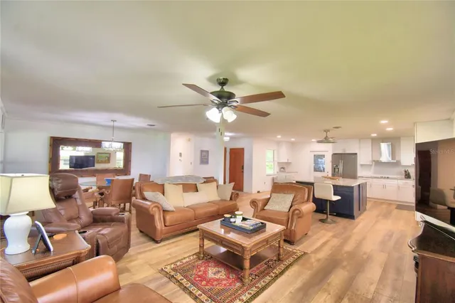 a living room with furniture a fireplace and a chandelier