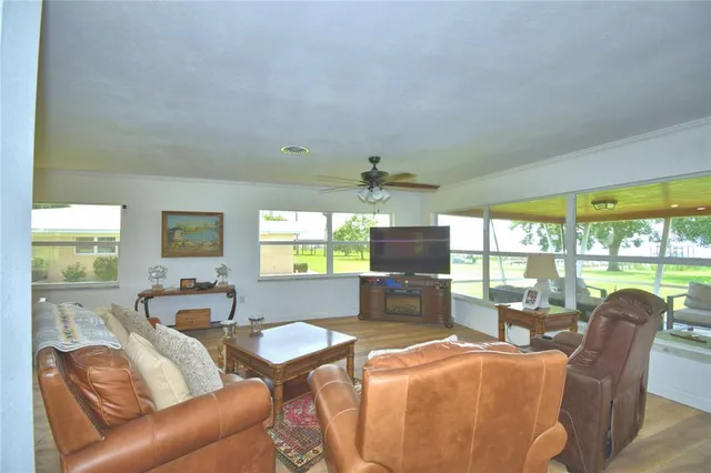 a living room with furniture a large window with kitchen view