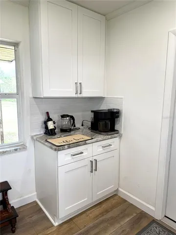 a kitchen with a stove and white cabinets