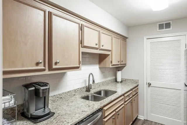 a kitchen with granite countertop a sink and a window