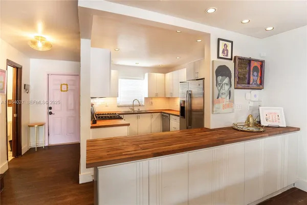 a kitchen with stainless steel appliances granite countertop a refrigerator and a sink