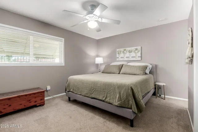 a bedroom with a bed and a ceiling fan