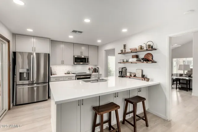 a kitchen with kitchen island a refrigerator stove and sink