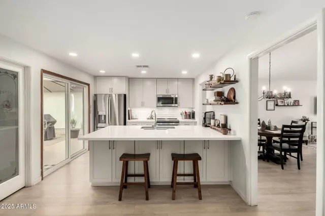 a kitchen with refrigerator and chairs