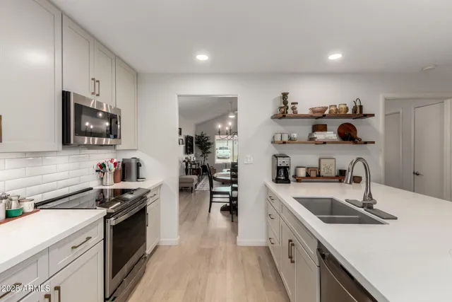 a kitchen with a sink a stove and cabinets