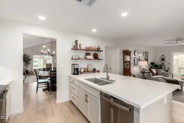 a open kitchen with sink stove and white cabinets with wooden floor