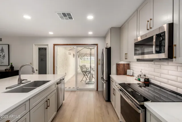 a kitchen with stainless steel appliances a sink stove and microwave