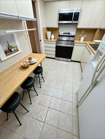 a kitchen with stainless steel appliances kitchen island granite countertop a sink and a stove