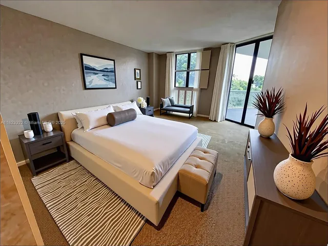 a bedroom with furniture and a large window