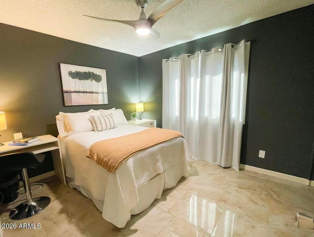 1255 East Riviera Drive Tempe, AZ 85282 - Photo 11 of 15 a spacious bedroom with a bed and a chandelier