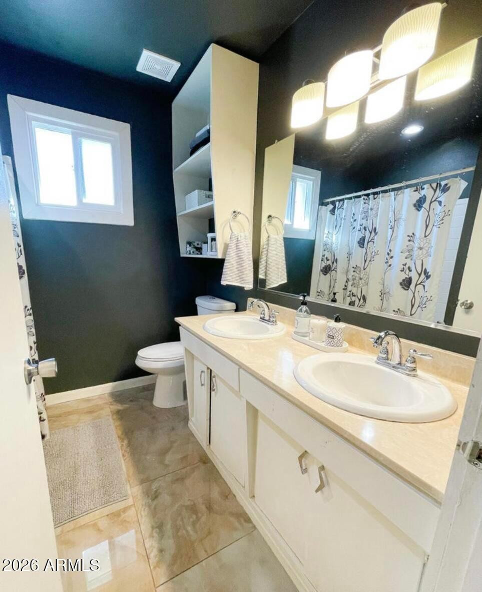 1255 East Riviera Drive Tempe, AZ 85282 - Photo 12 of 15 a bathroom with a double vanity sink mirror and toilet
