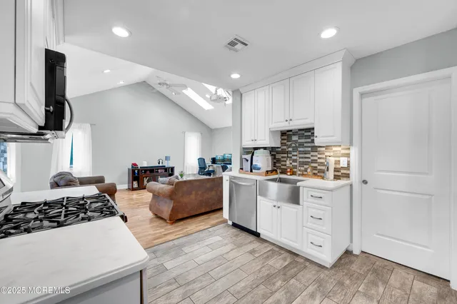 a kitchen with stainless steel appliances a stove a sink and a refrigerator