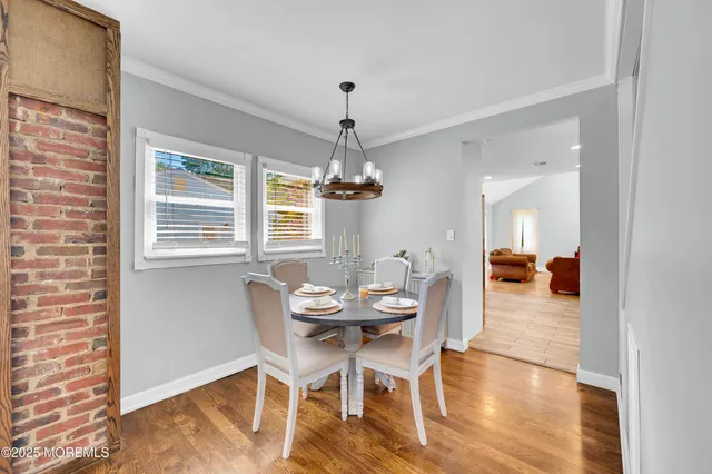 a dining room with furniture a chandelier and wooden floor