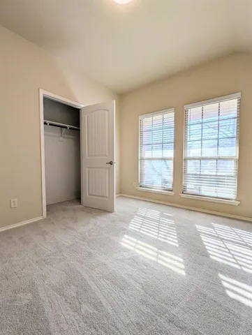 an empty room with windows and closet