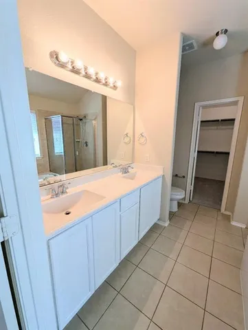 a spacious bathroom with a double vanity sink mirror and bathtub