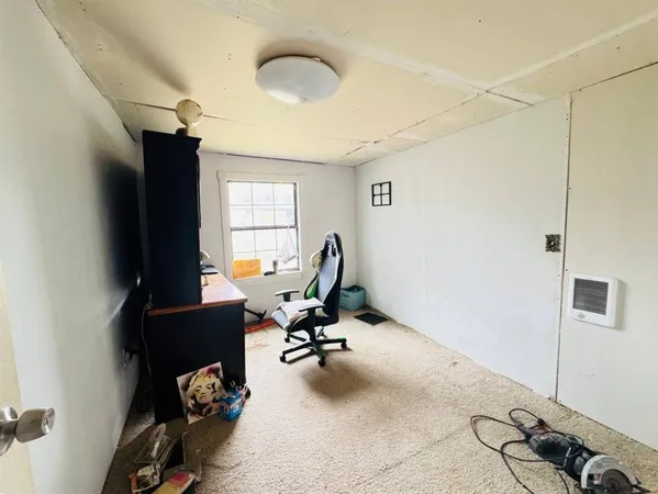 a view of a workspace with furniture and a window