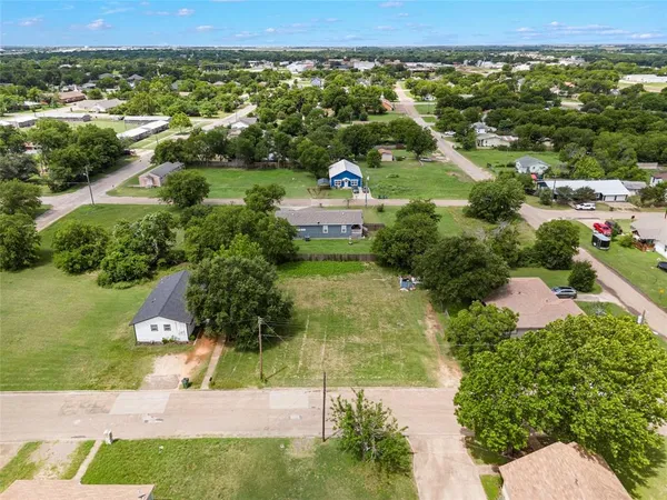an aerial view of residential houses with outdoor space and trees