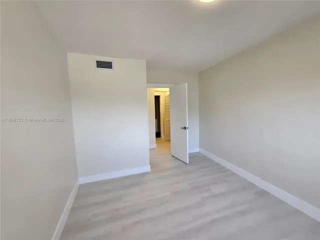 an empty room with wooden floor and closet