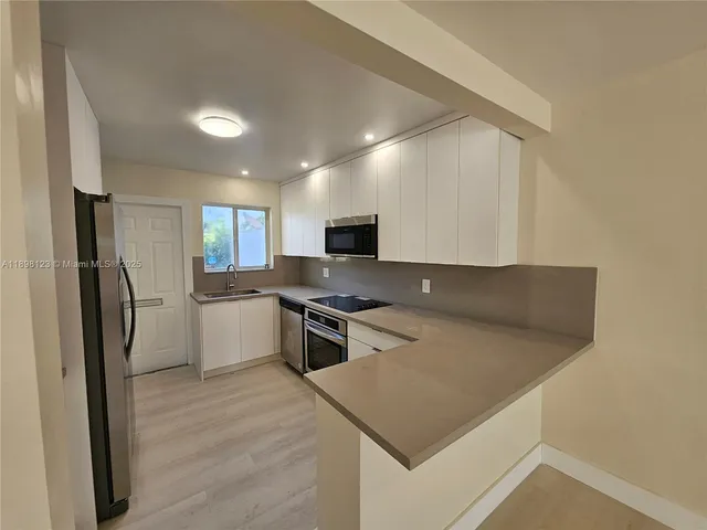 a view of a hallway with wooden floor and entryway
