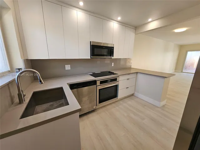 a spacious bedroom with a large bed and a painting on the wall