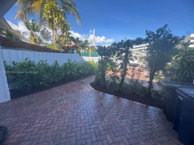 an aerial view of a city with lots of residential buildings ocean and mountain view in back