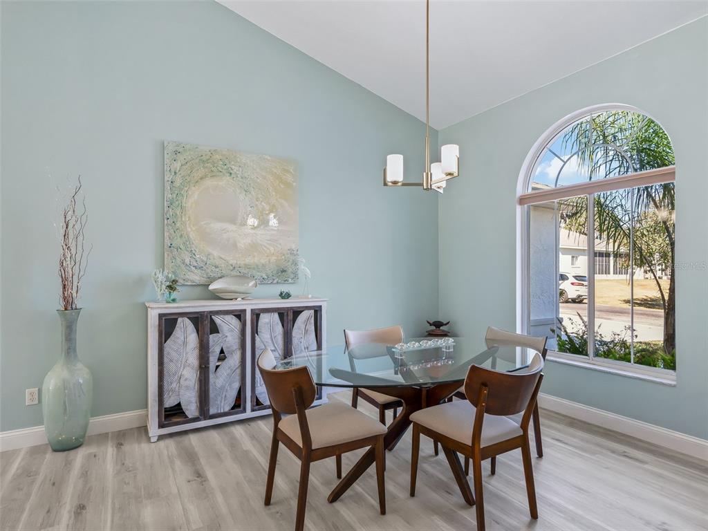 5016 Northwest 18th Street Ocala, FL 34482 - Photo 14 of 40 a dining room with furniture a chandelier and wooden floor