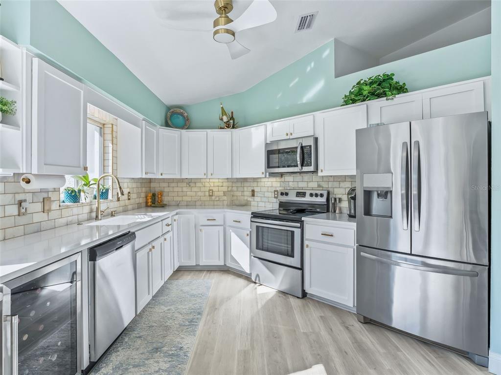 5016 Northwest 18th Street Ocala, FL 34482 - Photo 18 of 40 a kitchen with stainless steel appliances granite countertop a refrigerator a stove top oven a sink and dishwasher with wooden floor