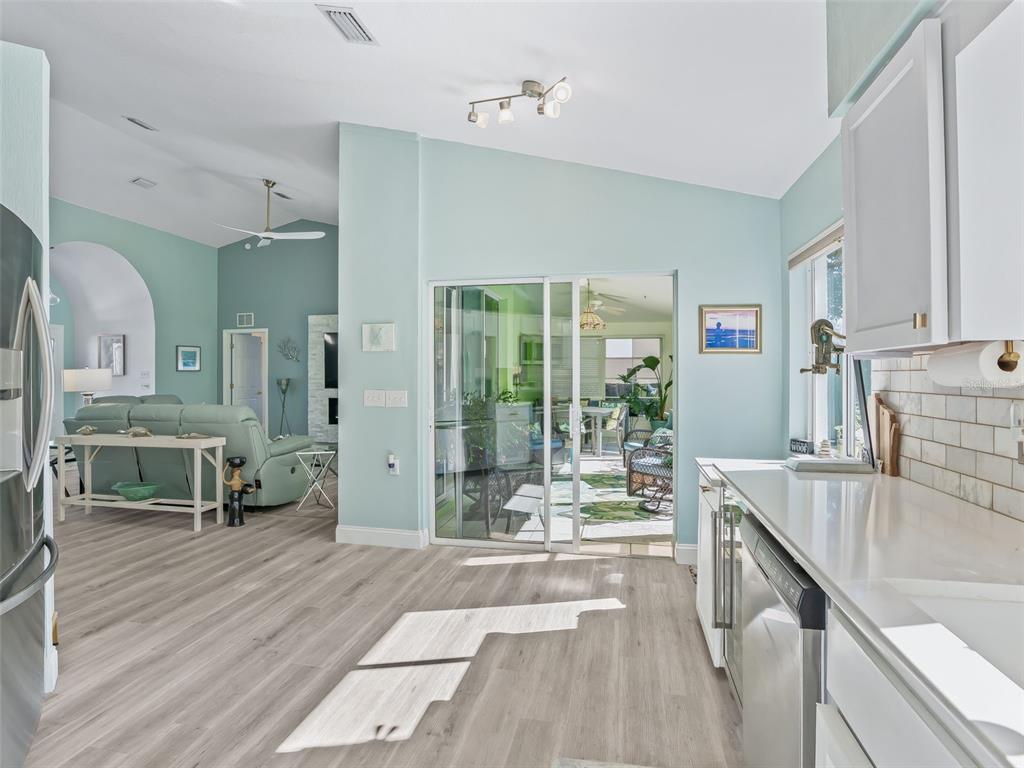 5016 Northwest 18th Street Ocala, FL 34482 - Photo 20 of 40 a living room with stainless steel appliances granite countertop a couch a dining table and chairs with wooden floor