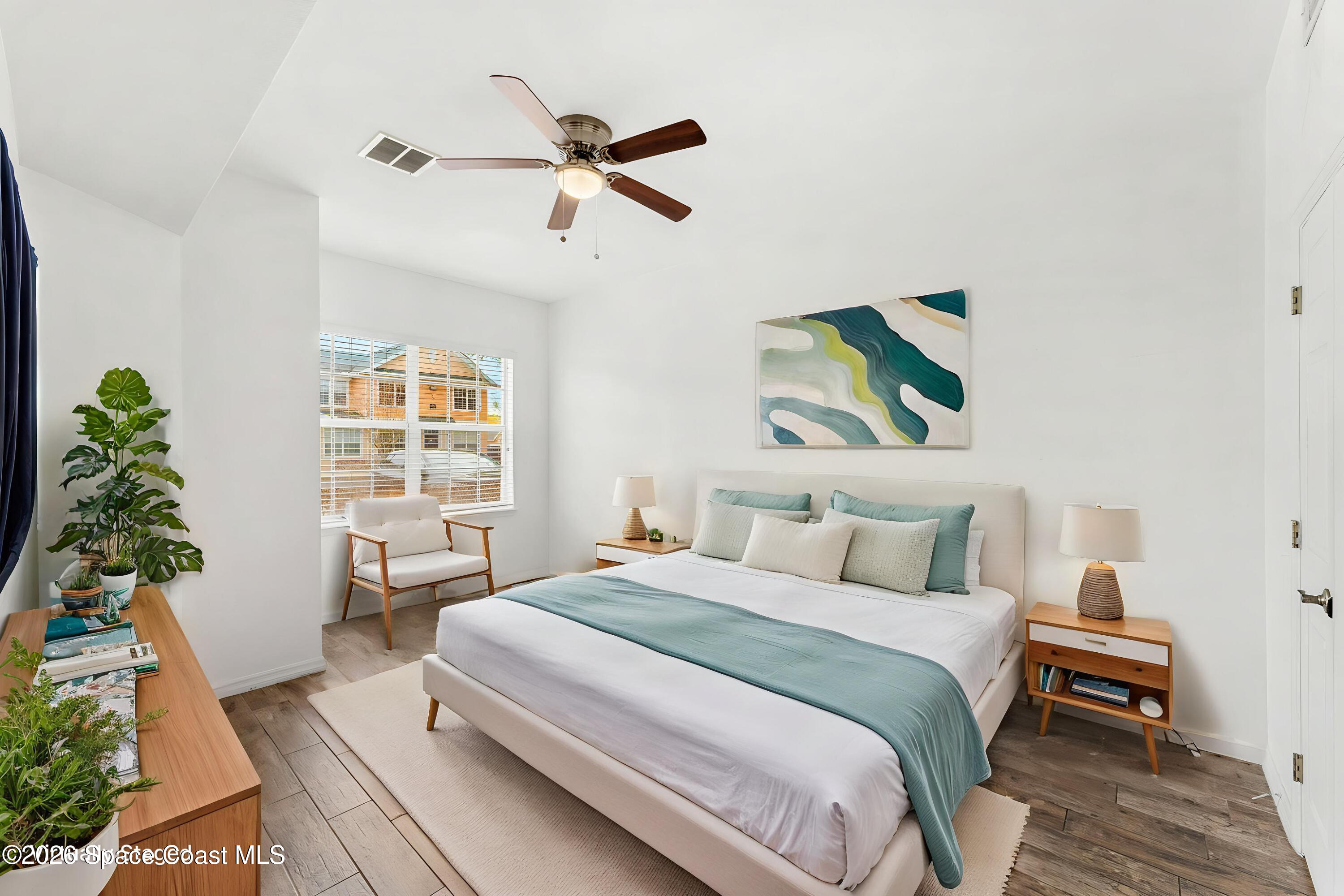 110 Turpial Way, Unit 102 Melbourne, FL 32901 - Photo 6 of 23 a bedroom with a bed and a potted plant