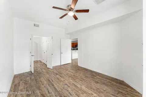 a view of empty room with wooden floor