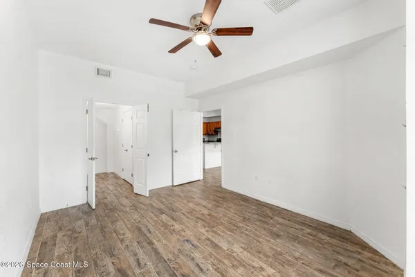 a view of empty room with wooden floor