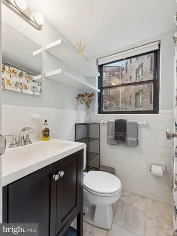 a bathroom with a sink a toilet and a mirror