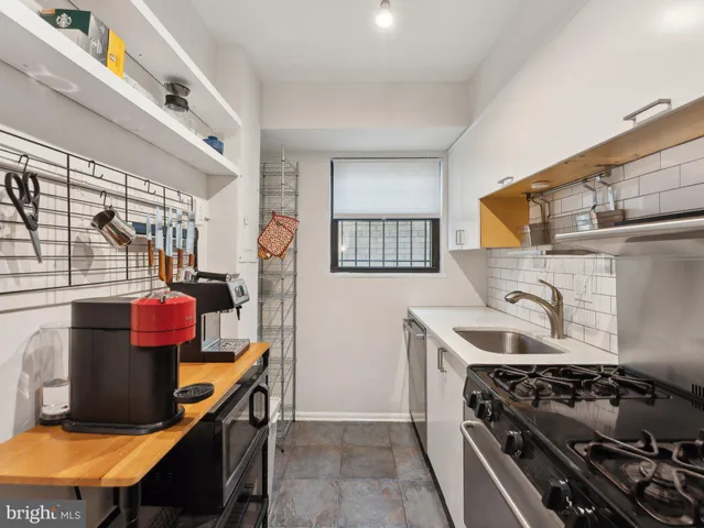 a kitchen with stainless steel appliances granite countertop a stove and cabinets