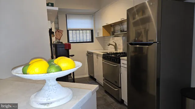 a view of a kitchen with a sink refrigerator and wooden floor