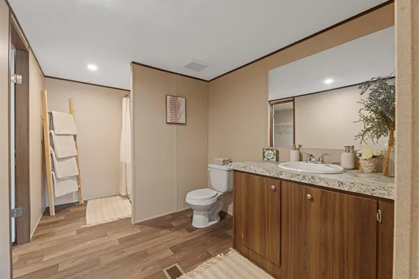 a bathroom with a granite countertop sink toilet and shower