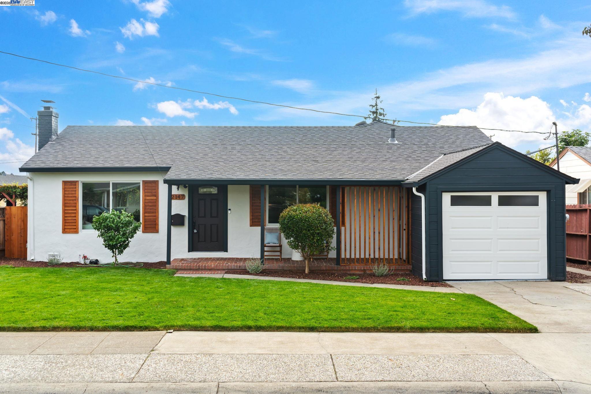 a front view of a house with a garden and plants