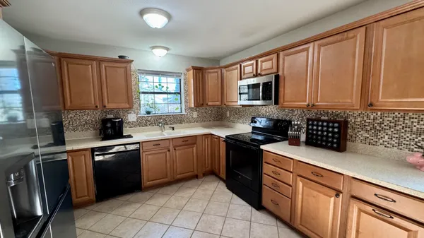 a kitchen with granite countertop a sink stainless steel appliances and cabinets