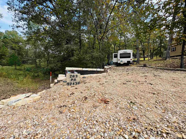 a backyard of a house with a bench and trees