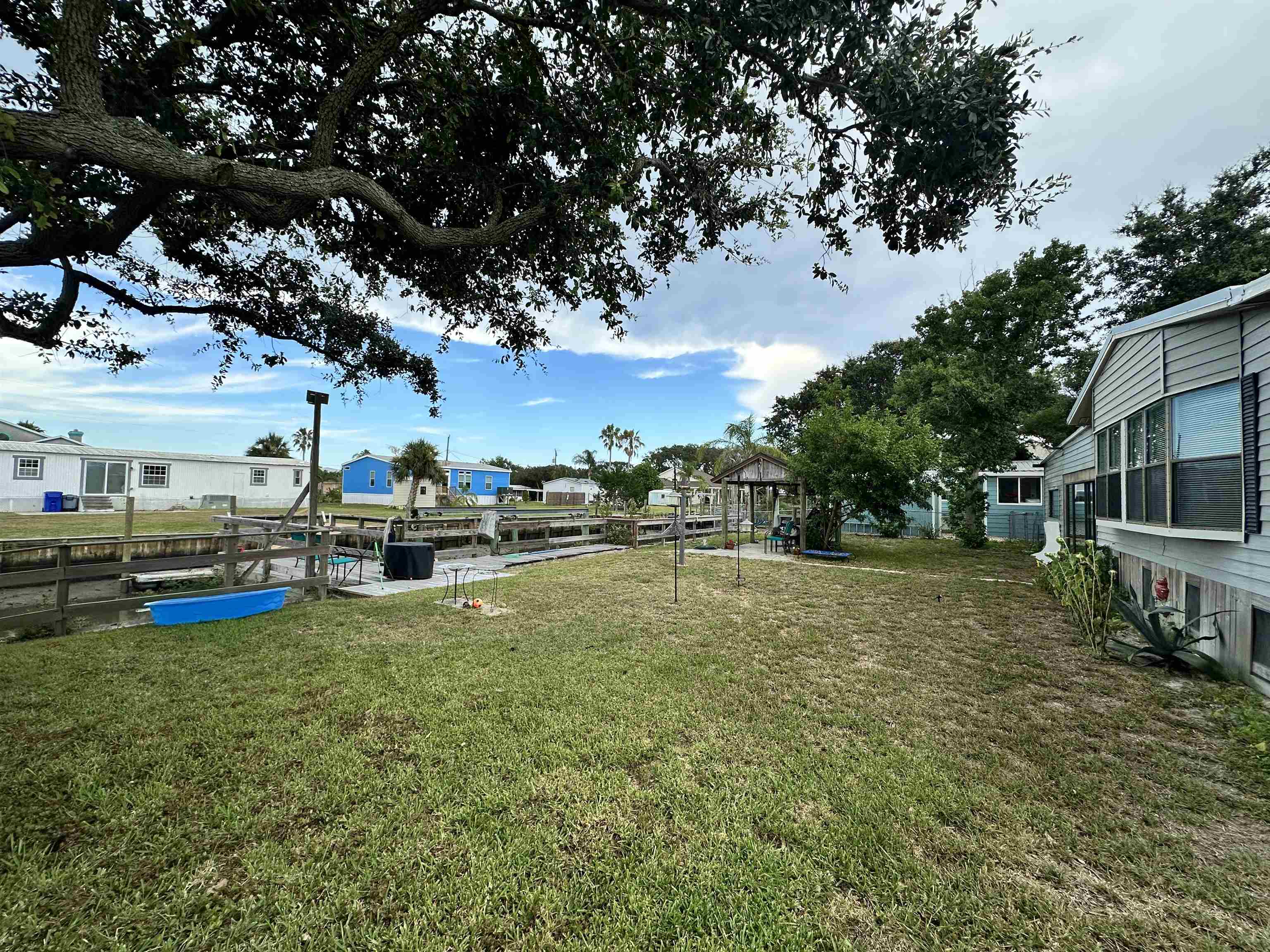 272 Pizarro Road St. Augustine, FL 32080 - Photo 12 of 23 a view of a swimming pool with lawn chairs and a big yard