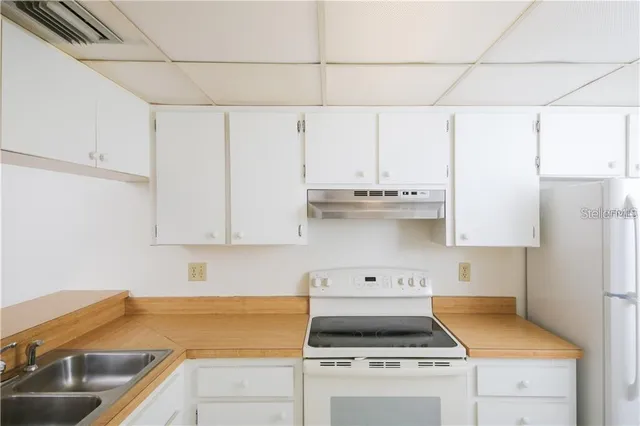 a kitchen with a sink a stove and cabinets