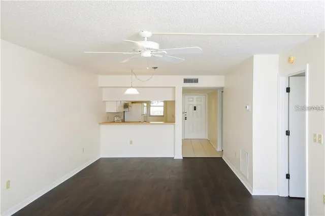 a view of a hallway with wooden floor and cabinet