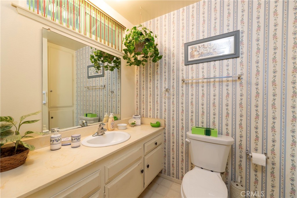 1085 Tamarack Avenue Brea, CA 92821 - Photo 17 of 28 a bathroom with a granite countertop sink a toilet and a mirror