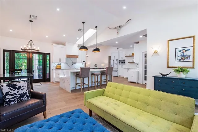 a living room with furniture kitchen view and a large window