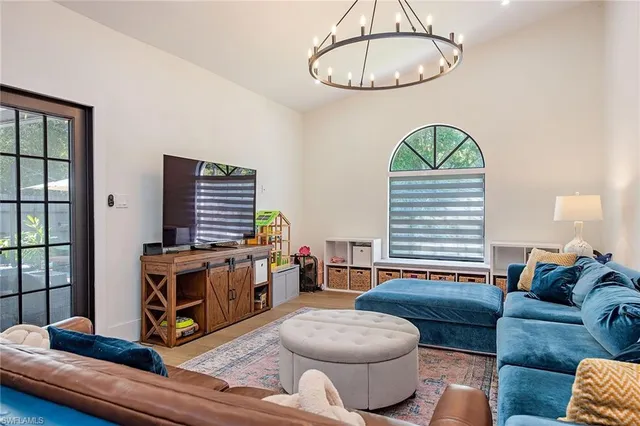 a living room with furniture a table and a large window