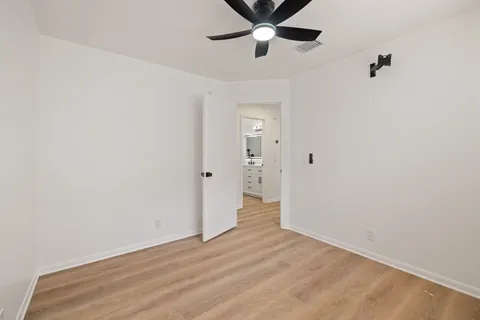 a view of a room with wooden floor and ceiling fan
