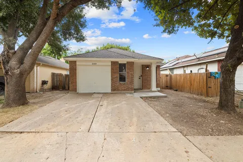 front view of a house with a yard and an trees