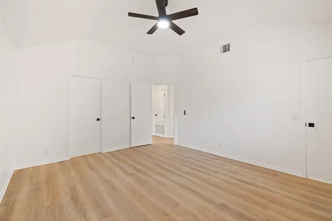 a view of empty room with wooden floor
