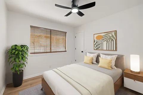 a bedroom with a bed and a potted plant